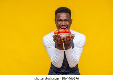 Portrait Of An Excited And Happy African Chef Holding A Plate Of Tomatoes