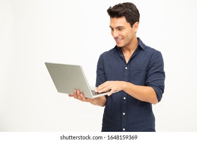 Portrait of an excited man holding laptop computer and celebrating success over white background, Raising arms with a look of happiness, Male model - Shutterstock ID 1648159369