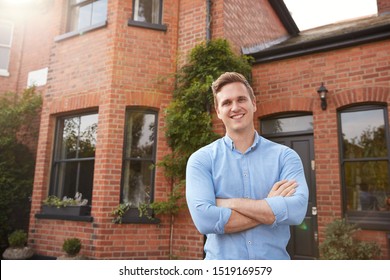 Portrait Of Excited Man Standing Outside New Home Holding Keys