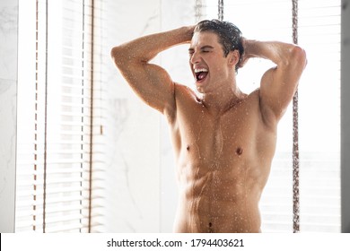 Portrait of excited man standing under cold shower with open mouth, screaming or singing, copy space