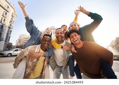 Portrait excited multi-ethnic group happy young friends piggyback enjoying great time outdoors and having fun together. Cheerful men carrying girlfriends on back. Looking at camera on vacation - Powered by Shutterstock