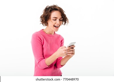 Portrait Of An Excited SMILING Girl Playing Games On Mobile Phone Isolated Over White Background