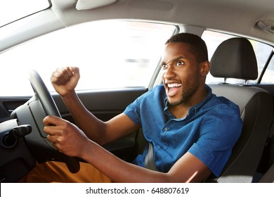 Portrait Of Excited Young African American Man Driving A Car