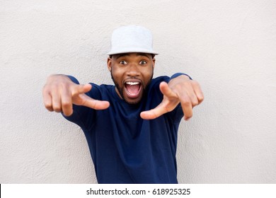 Portrait of excited young african man pointing at front with surprised expression