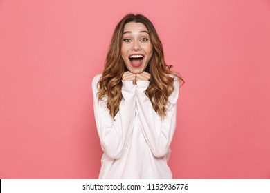 Portrait of an excited young casual girl screaming isolated over pink background