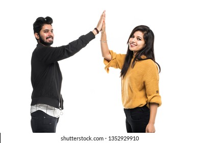 Portrait Of An Excited Young Couple Giving High Five Over Gray Background