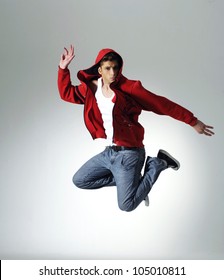 Portrait of an excited young man jumping in air against light background