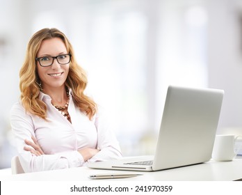 Portrait Of Executive Sales Woman Working At Laptop And Calculating Data While Sitting At Office. 