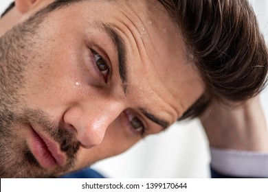 Portrait Of Exhausted Handsome Man With Sweaty Face Suffering From Heat On White