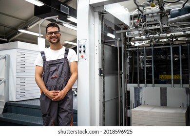 Portrait of an experienced typographer standing by modern printing machine in print house. - Shutterstock ID 2018596925