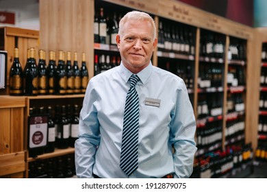 Portrait Of An Expert Sommelier Standing In Wine Store. Supermarket Liquor Section Manager Looking At Camera.