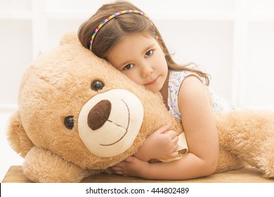 girl hugging a teddy bear