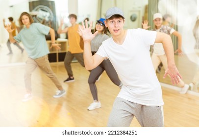 Portrait Of Expressive Teenage Krump Dancer In Choreographic Studio With Dancing Teenagers In Background. Typical Generation Z .