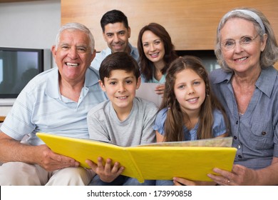 Portrait Of An Extended Family Looking At Their Album Photo In The Living Room