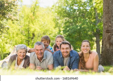 Portrait Of An Extended Family Lying On Grass In The Park