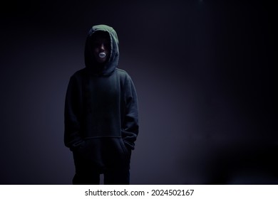 A Portrait Of A Faceless Child In The Hoodie, Blowing The Bubble Gum, Standing In The Dark Environment, Horizontal