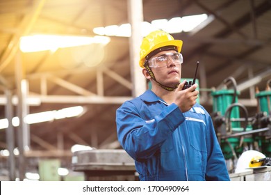 Portrait Of Factory Worker And Engineer At Industrial Facility. Construction Worker In Hardhat And Walkie-talkie Or Two Way Radio In Hand