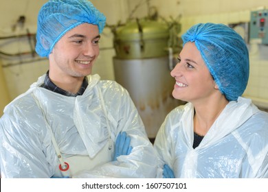 portrait of factory workers smiling in front of vat