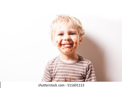 Portrait of fair-haired boy with chocolate on his face isolated on white