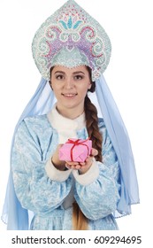 Portrait of a fairy-tale Snow Maiden in a blue suit and kokoshnik with a veil, gives a gift in a pink box