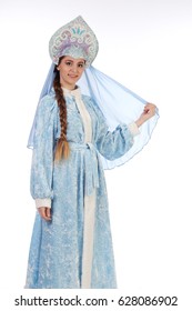 Portrait of a fairy-tale Snow Maiden in a blue suit and kokoshnik with a veil on a white background studio