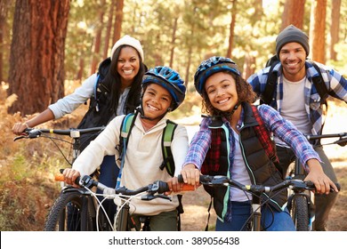 Portrait Of Family Cycling Through Fall Woodland