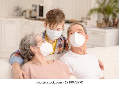 Portrait Of A Family During The Coronavirus Pandemic. Old People In Medical Masks Communicate With A Child At Home