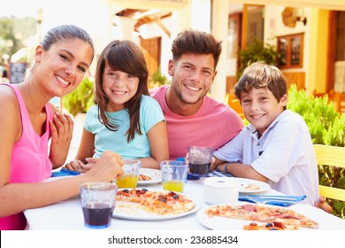 Portrait Of Family Eating Meal At Outdoor Restaurant