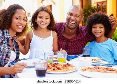 Portrait Of Family Eating Meal At Outdoor Restaurant