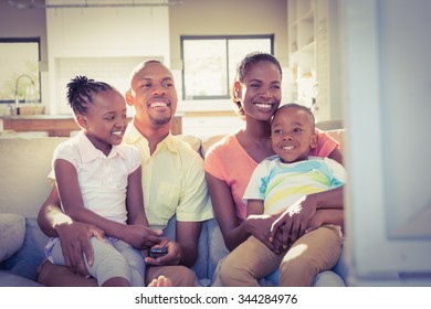 Portrait Of A Family Of Four Watching Tv In Living Room