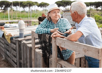 Portrait of family of gardeners near wooden girders in garden outdoor - Shutterstock ID 2364892137