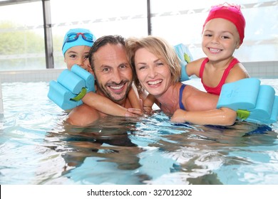 Portrait Of Family Having Fun In Public Indoor Swimming-pool