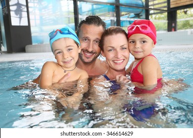 Portrait Of Family Having Fun In Public Indoor Swimming-pool