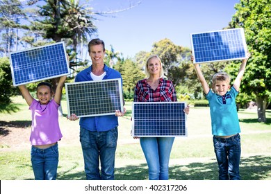 Portrait Of Family Holding A Solar Panel In Park