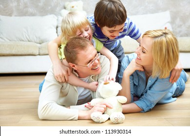 Portrait Of Family Lying On Floor Living Room And Smiling To Camera