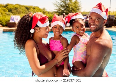 Portrait Of Family On Christmas Holiday In Swimming Pool Wearing Santa Hats - Powered by Shutterstock