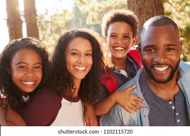 Portrait Of Family On Hiking Adventure Through Woods