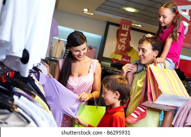 Portrait Of A Family With Shopping Bags Choosing New Clothes In The Mall