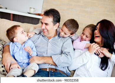 Portrait Of A Family Sitting Inside The House And Smiling