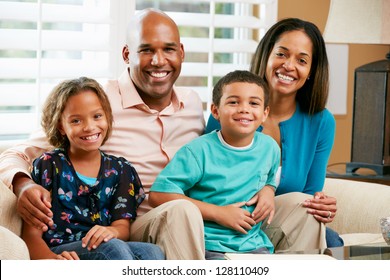 Portrait Of Family Sitting On Sofa Together