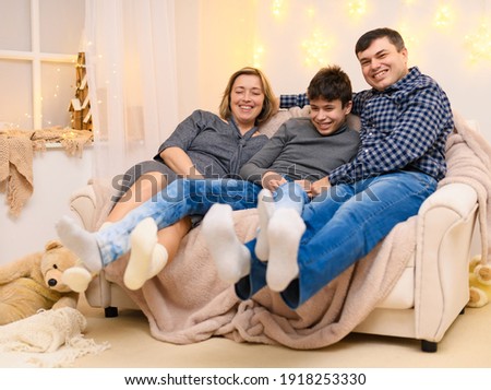 portrait of a family sitting on a sofa at home.