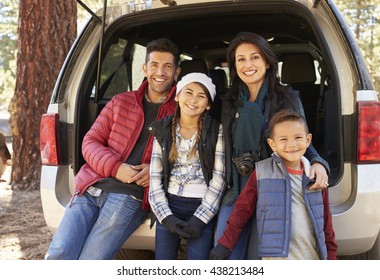 Portrait Of Family Sitting In Open Back Of Car Before A Hike