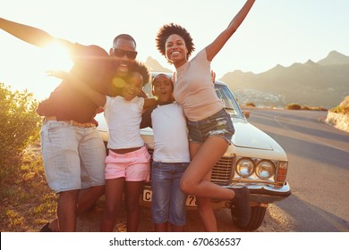 Portrait Of Family Standing Next To Classic Car