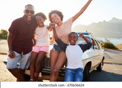 Portrait Of Family Standing Next To Classic Car