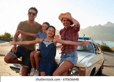 Portrait Of Family Standing Next To Classic Car