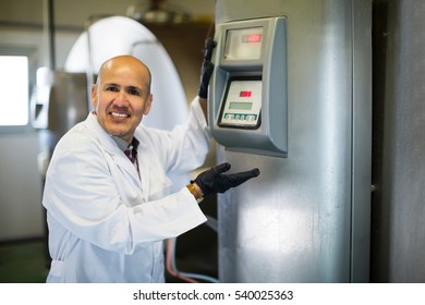 Portrait Of Farm Worker Near Cisterns With Raw Milk

