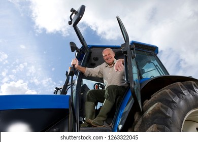 Portrait of farmer in cab driving tractor working on farm - Powered by Shutterstock