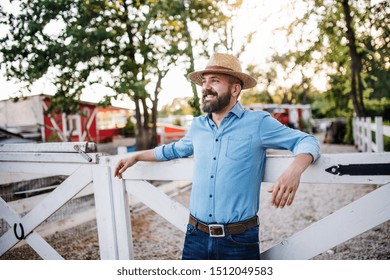 A Portrait Of Farmer Standing Outdoors On Family Farm. Copy Space.