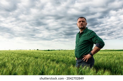 Portrait Of Farmer Standing In Wheat Field.