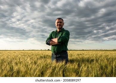 Porträt von Landwirten, die auf Weizenfeld stehen.